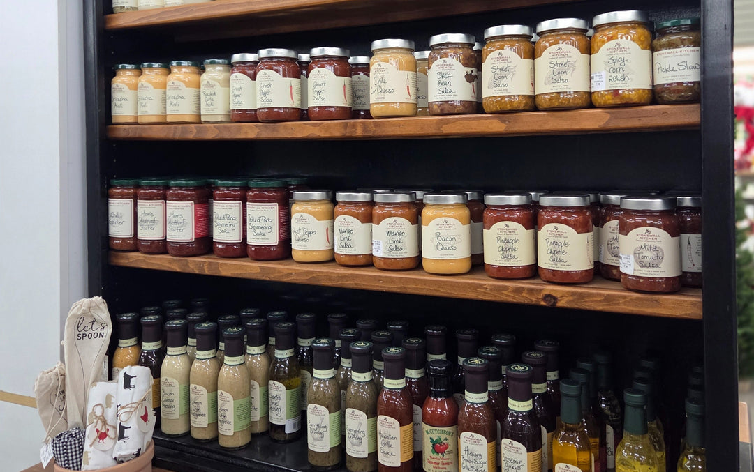 Shelf with various jars and bottles of sauces and condiments.