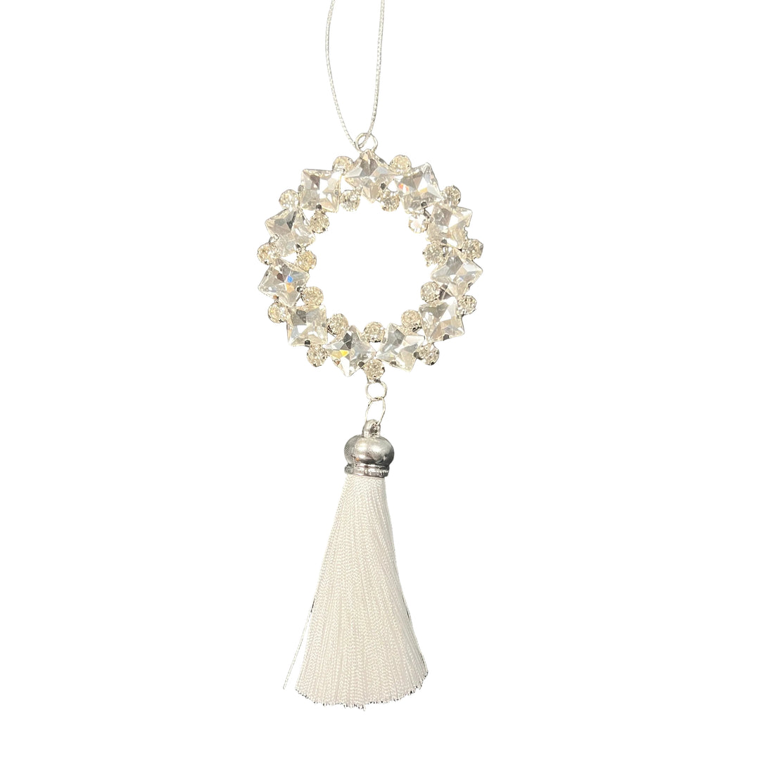 Decorative hanging ornament with crystal wreath and white tassel on a textured black background